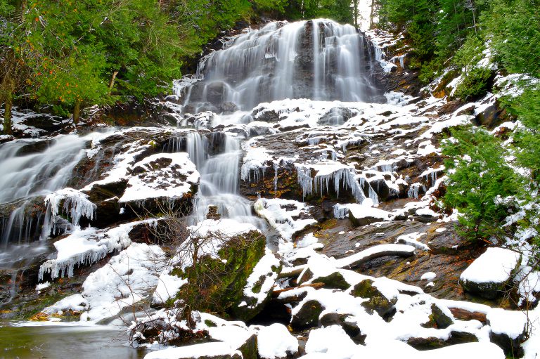 Long exposure picture of a Beaver Falls in Colebrook New Hampshire. Snow covers the rocks.